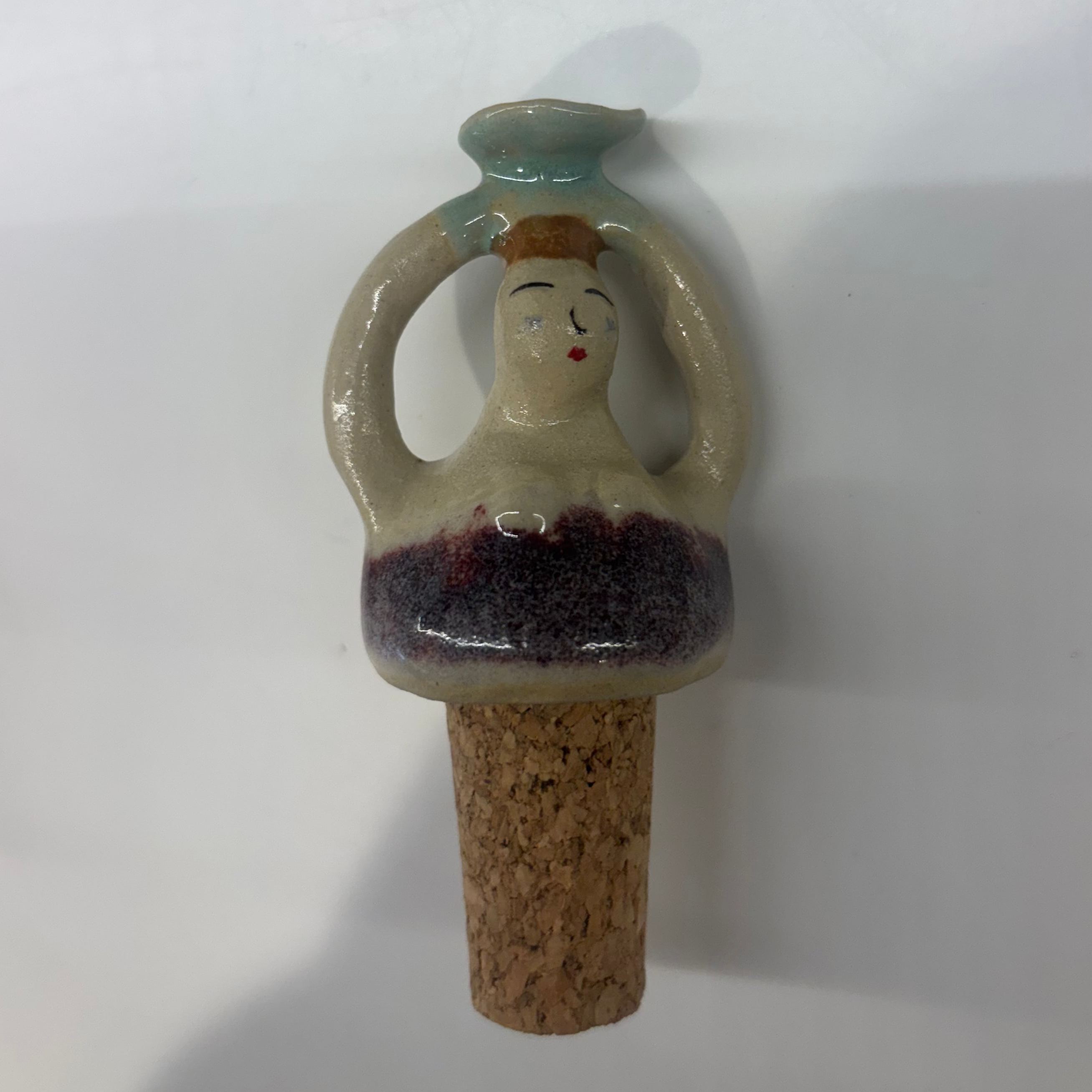 Ceramic bottle stopper with face design on a white background